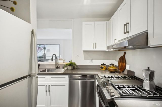a kitchen with stainless steel appliances a stove a sink and cabinets
