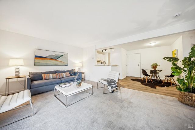 a living room with furniture and a potted plant on table