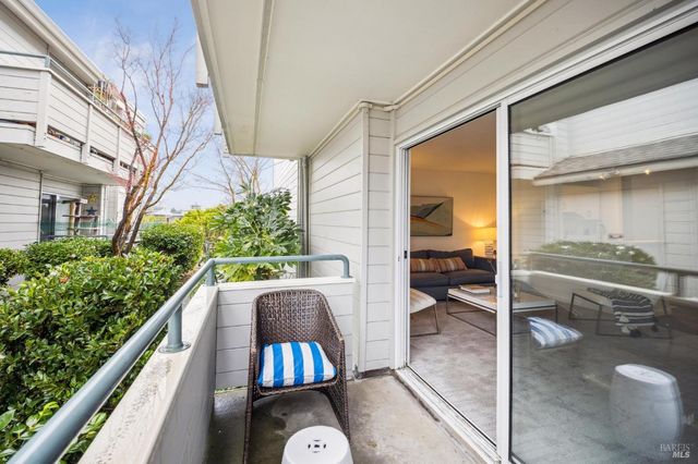 a view of balcony with two chairs and a potted plant