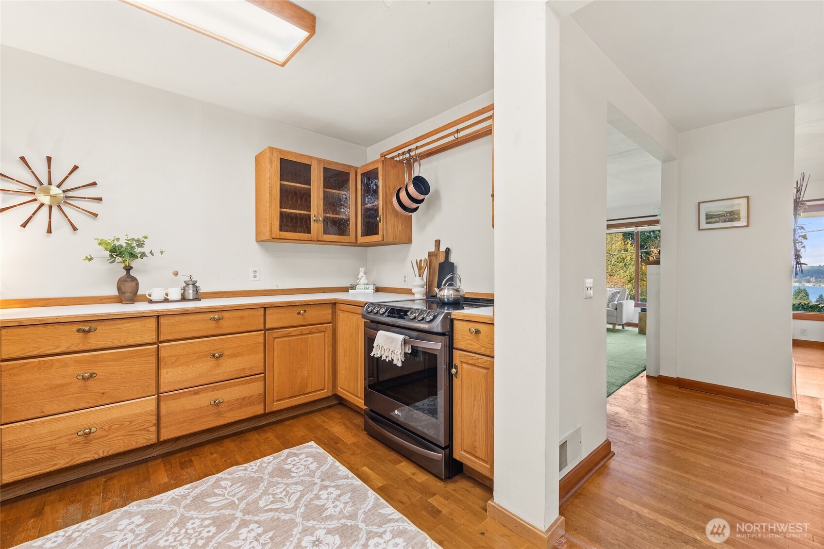9619 Southwest 268th Street Vashon, WA 98070 - Photo 17 of 37 a hall with kitchen island white cabinets and stainless steel appliances