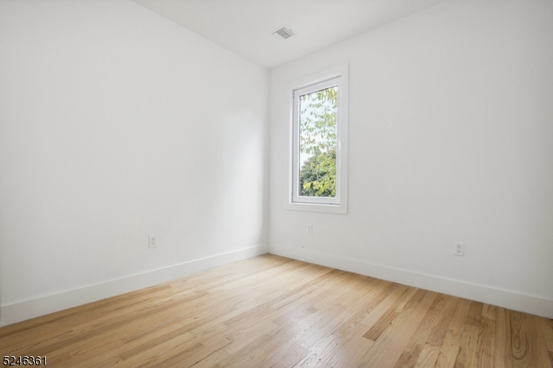 492 South 20th Street, Unit 2 Newark, NJ 07103 - Photo 12 of 12 an empty room with wooden floor and windows