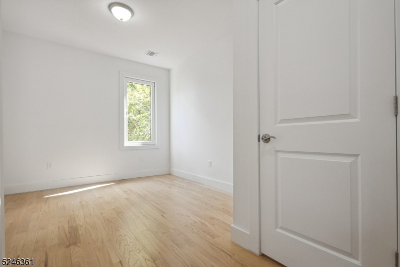 492 South 20th Street, Unit 2 Newark, NJ 07103 - Photo 9 of 12 an empty room with wooden floor and windows