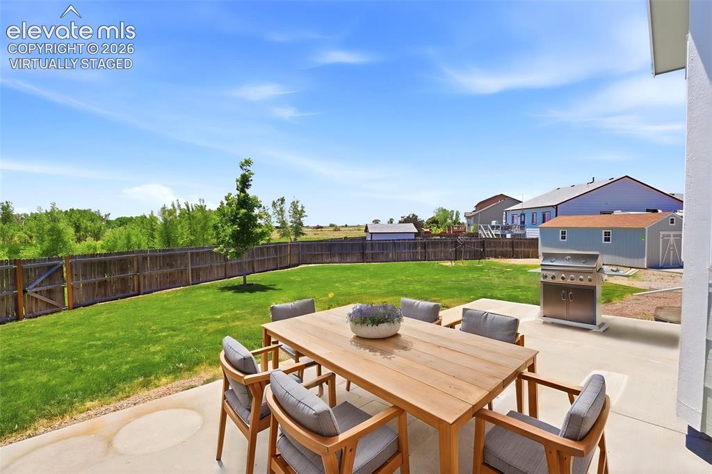 7806 Dutch Loop Colorado Springs, CO 80925 - Photo 28 of 41 a view of a patio with couches chairs and a table and chairs with wooden fence