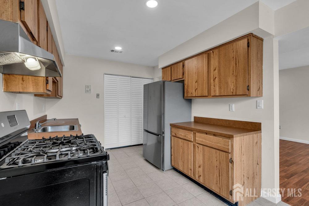 1610 Raspberry Court Edison, NJ 08817 - Photo 8 of 18 a kitchen with stainless steel appliances granite countertop a stove and a refrigerator