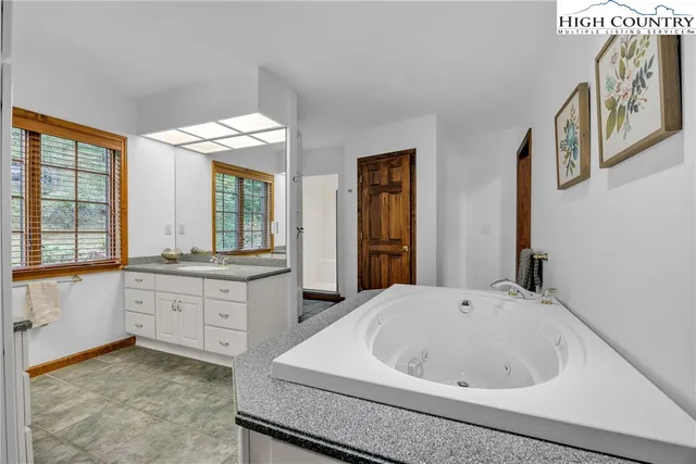 a bathroom with a granite countertop sink and large window