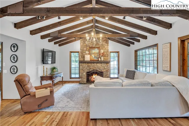 a living room with fireplace furniture and a large window