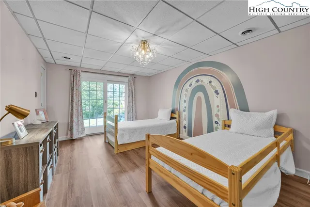 a living room with a large bed and chandelier