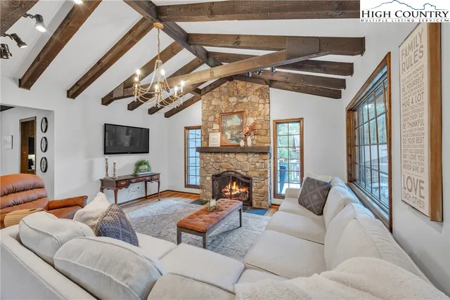 a living room with furniture a fireplace and a flat screen tv