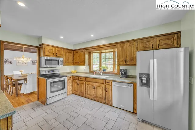 a kitchen with stainless steel appliances granite countertop a refrigerator and a stove top oven
