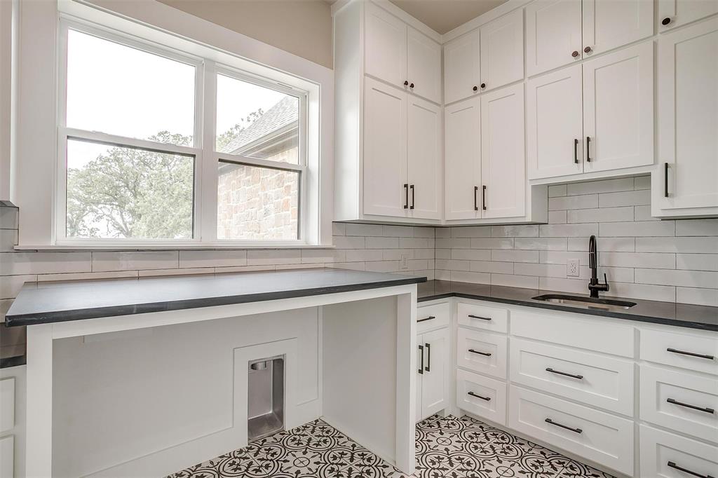 3019 Orchard Road Bowie, TX 76230 - Photo 30 of 40 a kitchen with granite countertop white cabinets and a window