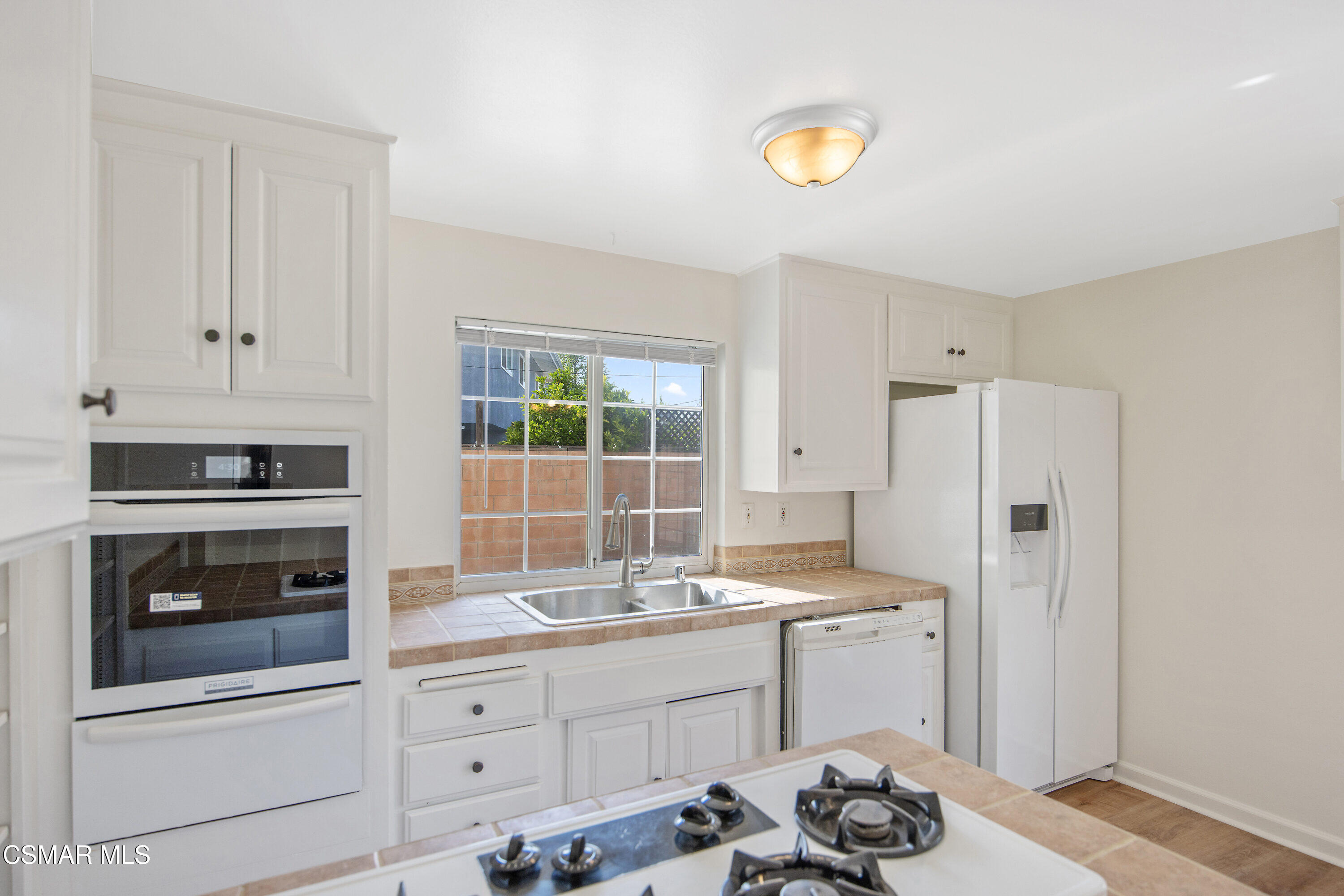 2087 Rhoda Street Simi Valley, CA 93065 - Photo 4 of 22 a kitchen with granite countertop white cabinets and white appliances