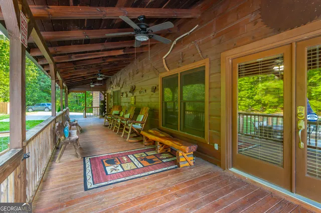 a backyard of a house with wooden floor pool table and chairs