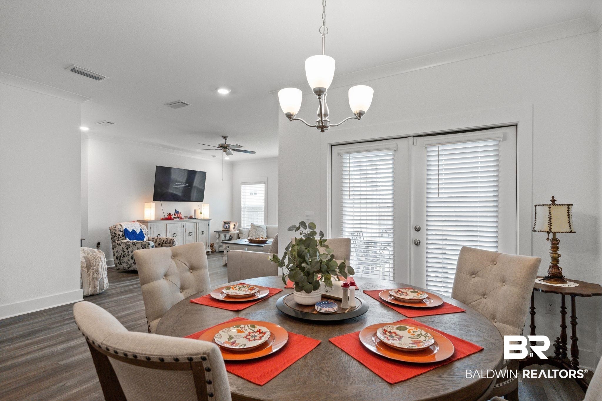8508 Rosedown Lane Daphne, AL 36526 - Photo 13 of 29 Dining area featuring a contemporary chandelier, wood-finish flooring, and white French doors with integrated blinds