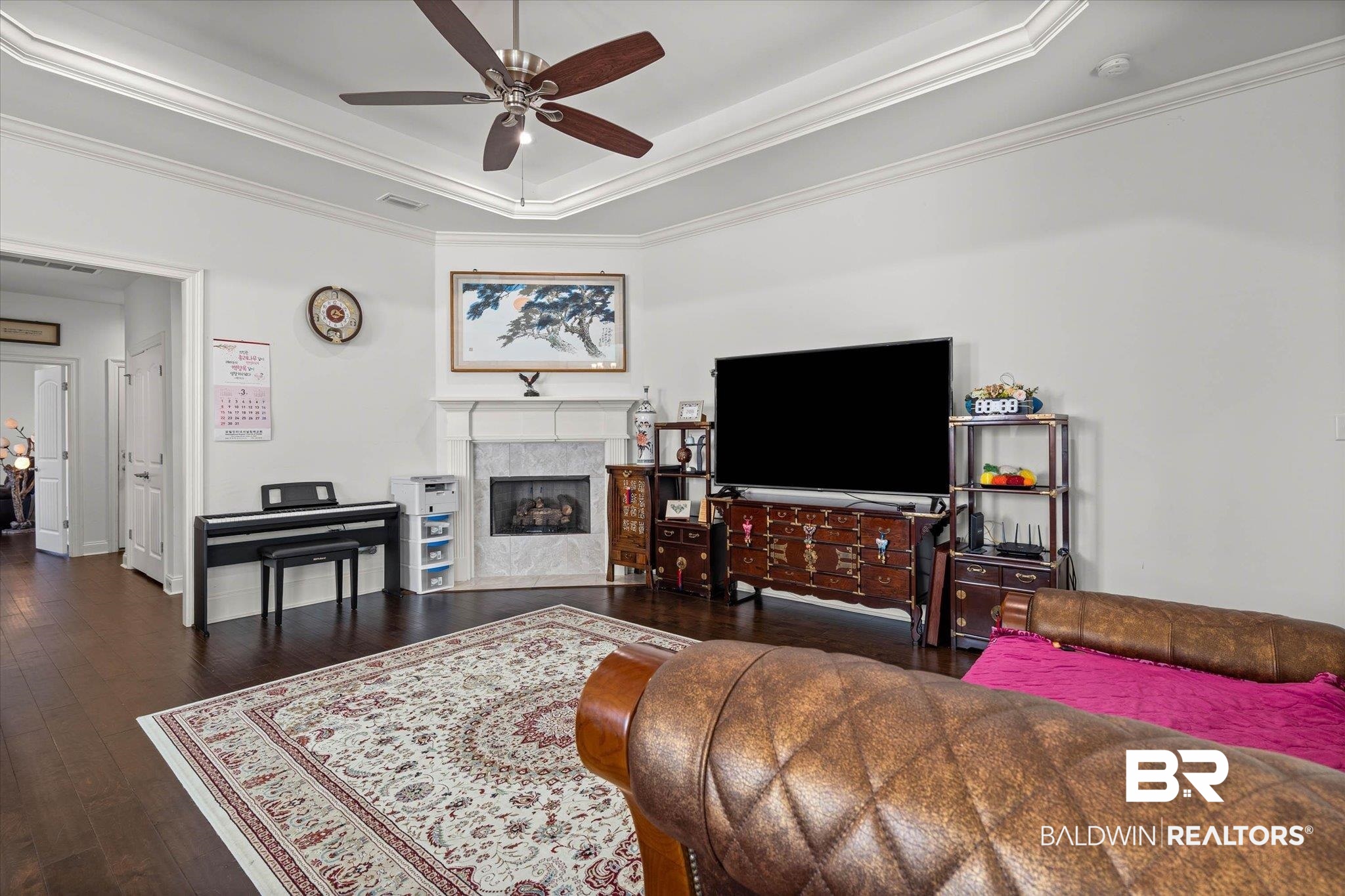 3528 Rue Royal Mobile, AL 36693 - Photo 17 of 53 Living room featuring crown molding, dark wood-style floors, ceiling fan, a tray ceiling, and a high end fireplace