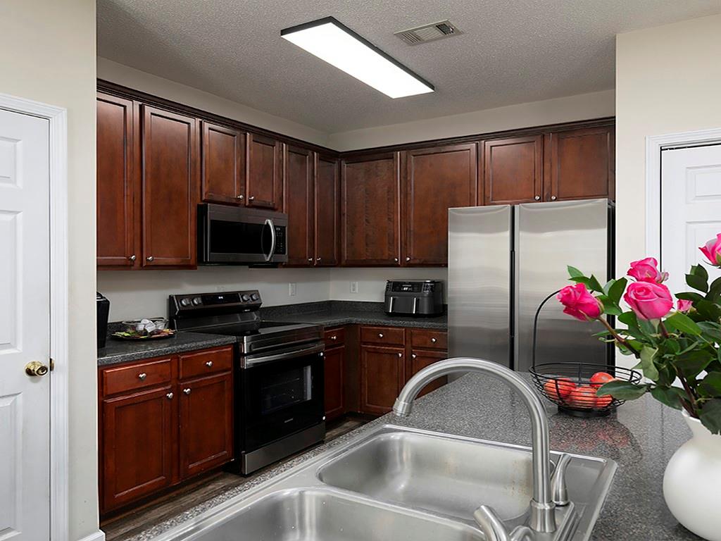 7699 Bucknell Terrace Fairburn, GA 30213 - Photo 11 of 34 a kitchen with granite countertop a sink stainless steel appliances and cabinets