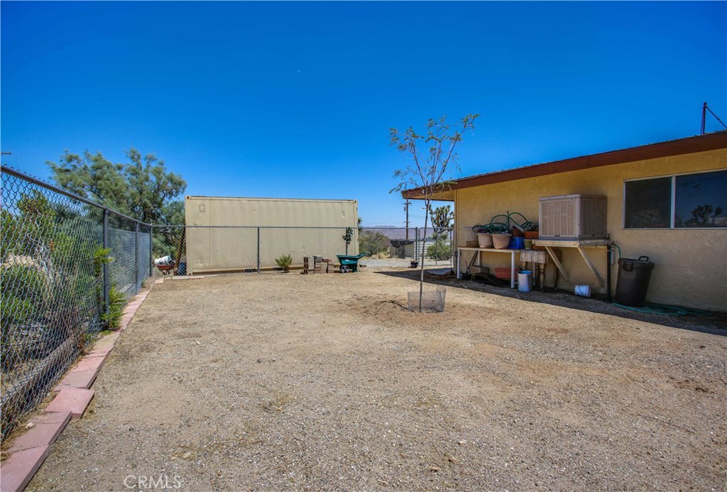5407 Paradise View Road Yucca Valley, CA 92284 - Photo 58 of 63 a backyard of a house with table and chairs under an umbrella