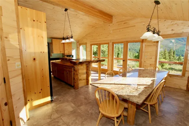 a view of a dining room and livingroom with furniture wooden floor a chandelier