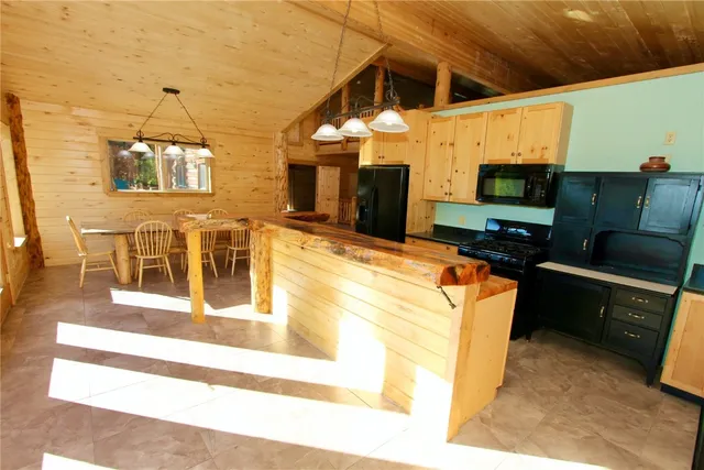 a living room with furniture a flat screen tv and kitchen view