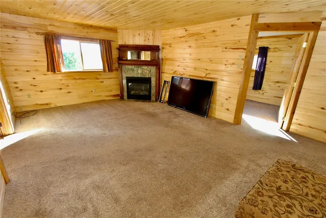 a view of an empty room with a fireplace and a window