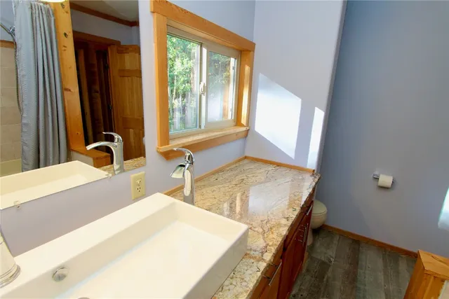a bathroom with a granite countertop sink and a large mirror