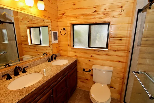 a bathroom with a granite countertop toilet sink and mirror