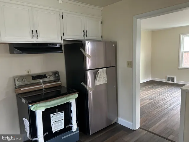 a kitchen with stainless steel appliances granite countertop a refrigerator a stove and a wooden floors