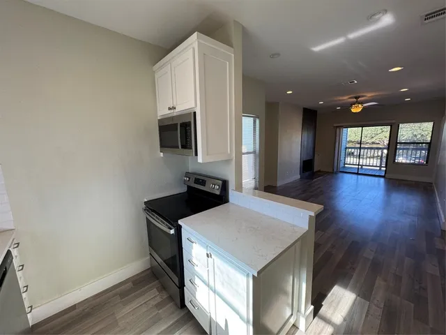 a kitchen with a sink a microwave and wooden floor