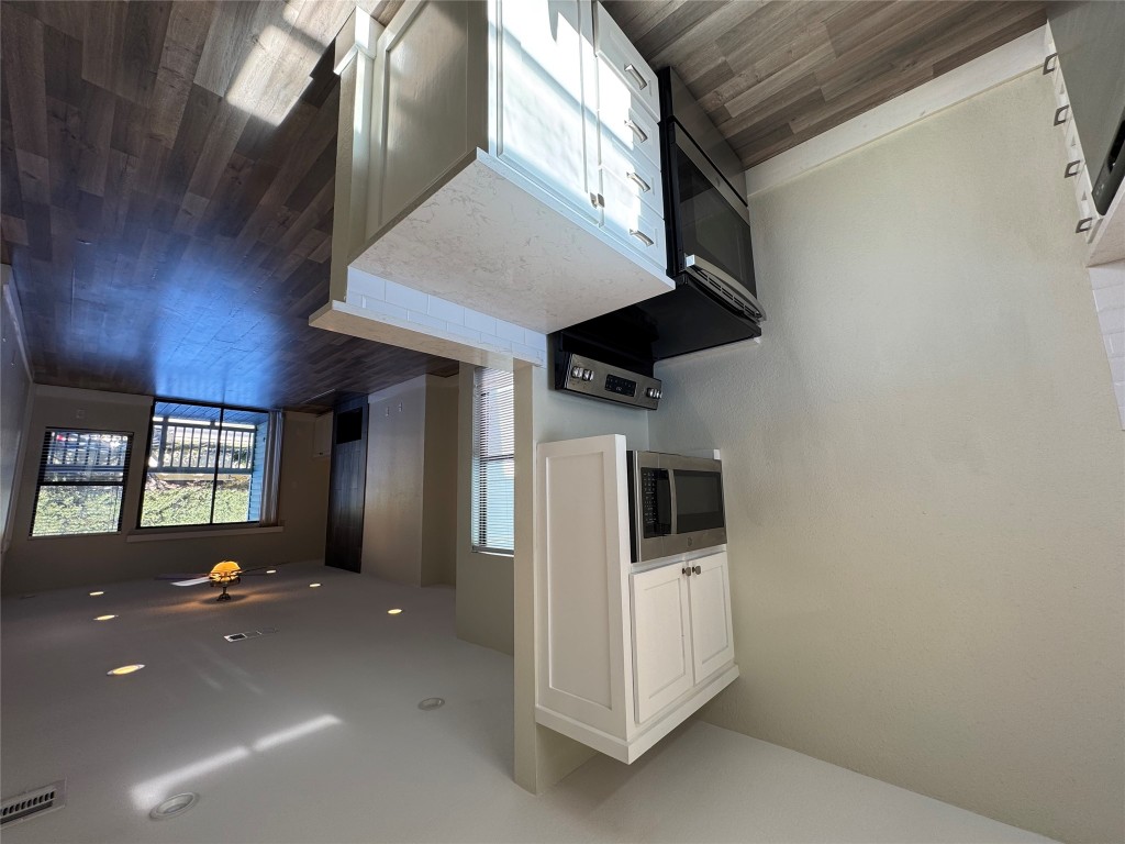 2417 West Slaughter Lane, Unit D Austin, TX 78748 - Photo 4 of 13 a kitchen with a sink a microwave and wooden floor