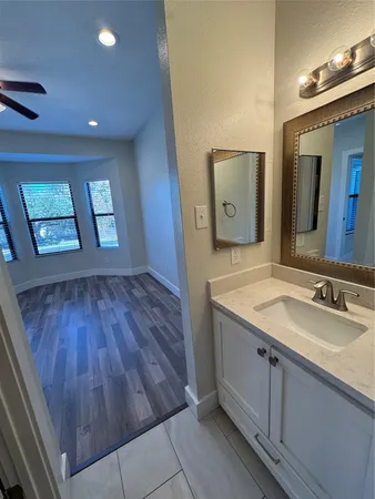 a bathroom with a granite countertop sink and mirror