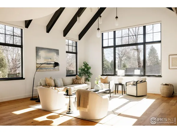 a living room with furniture a large window and dining table