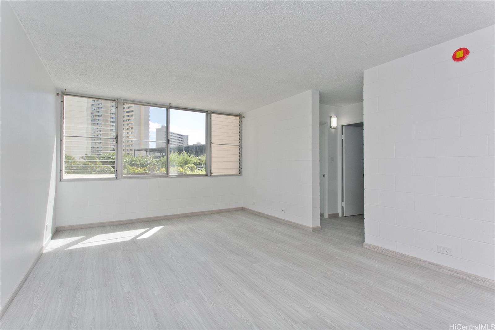 5122 Likini Street, Unit 214 Honolulu, HI 96818 - Photo 2 of 11 an empty room with wooden floor and windows