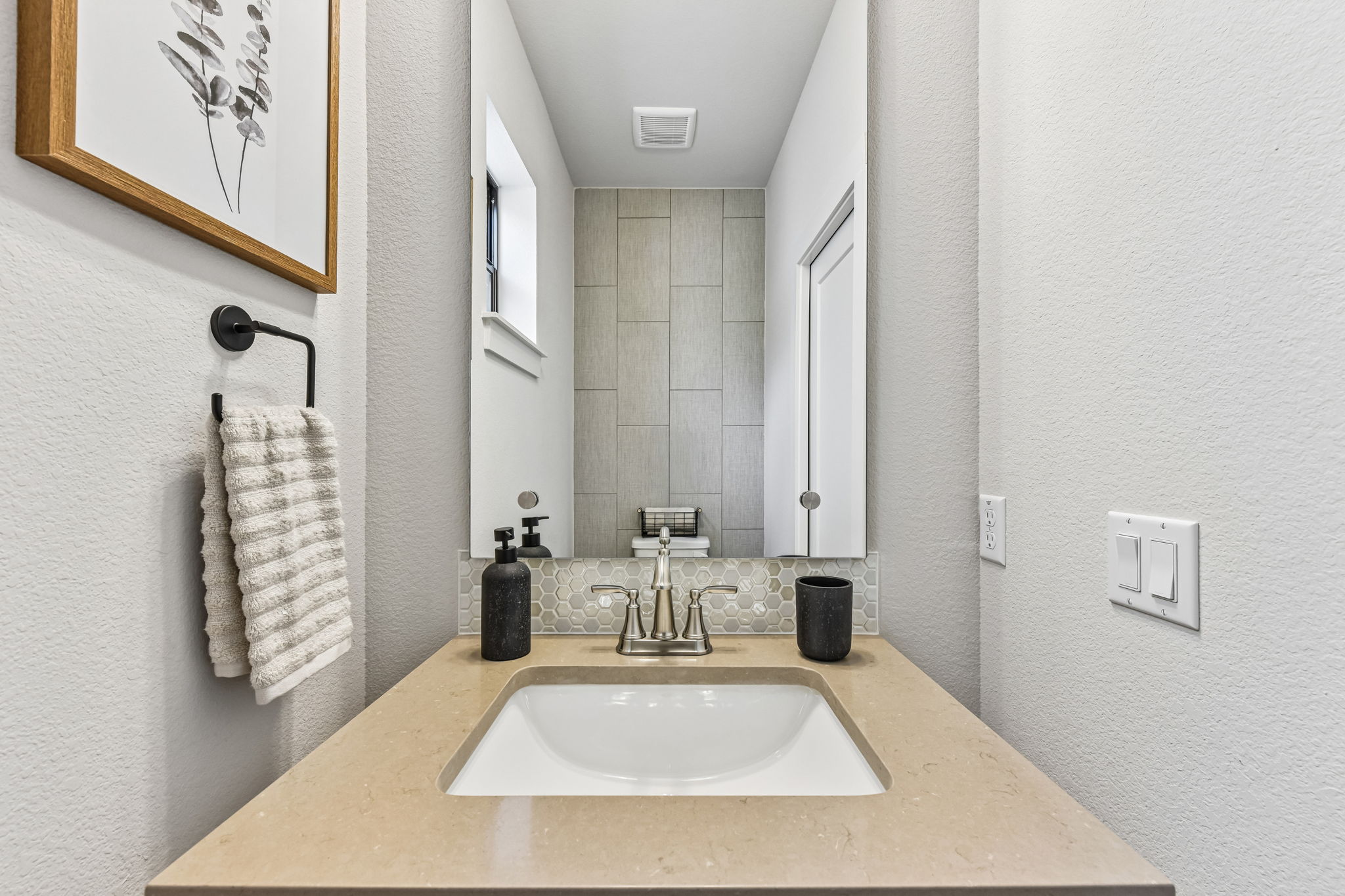 9033 Cattle Baron Path Austin, TX 78747 - Photo 24 of 40 A sleek vanity with an integrated sink complements the contemporary tile backsplash in this well-appointed bathroom.