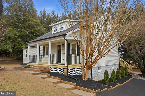 a front view of a house with a tree