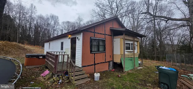 a view of a house with a yard and large trees