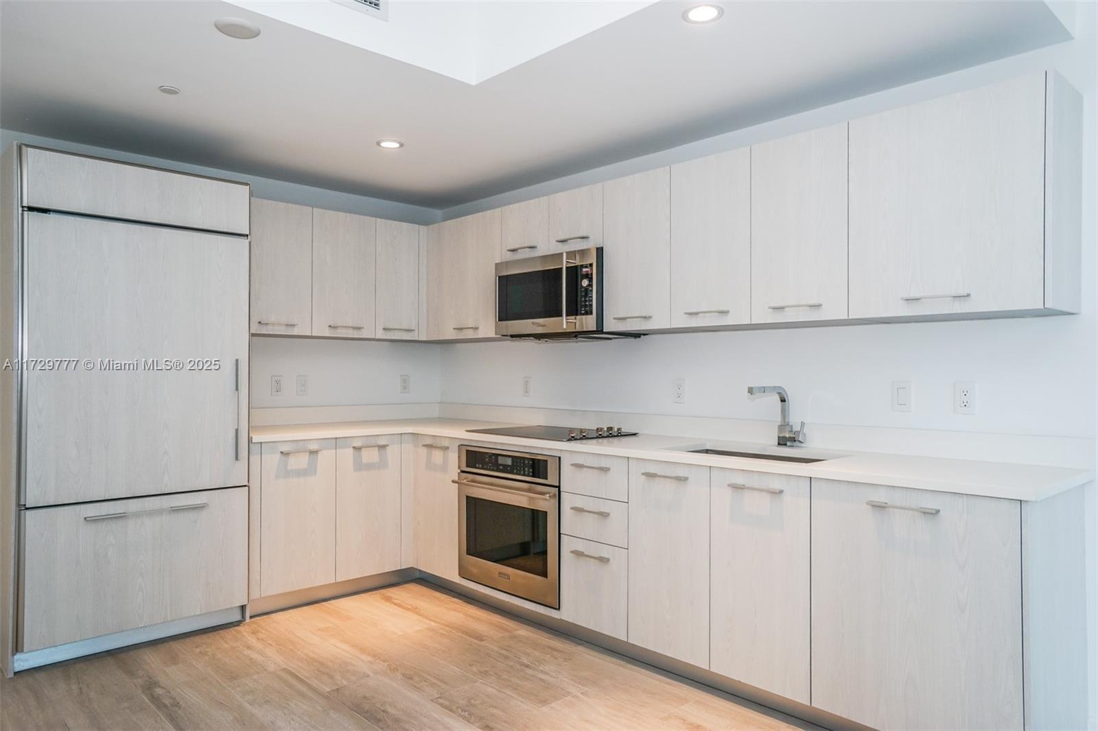 Brickell Miami, FL 33130 - Photo 4 of 24 a kitchen with white cabinets stainless steel appliances and sink