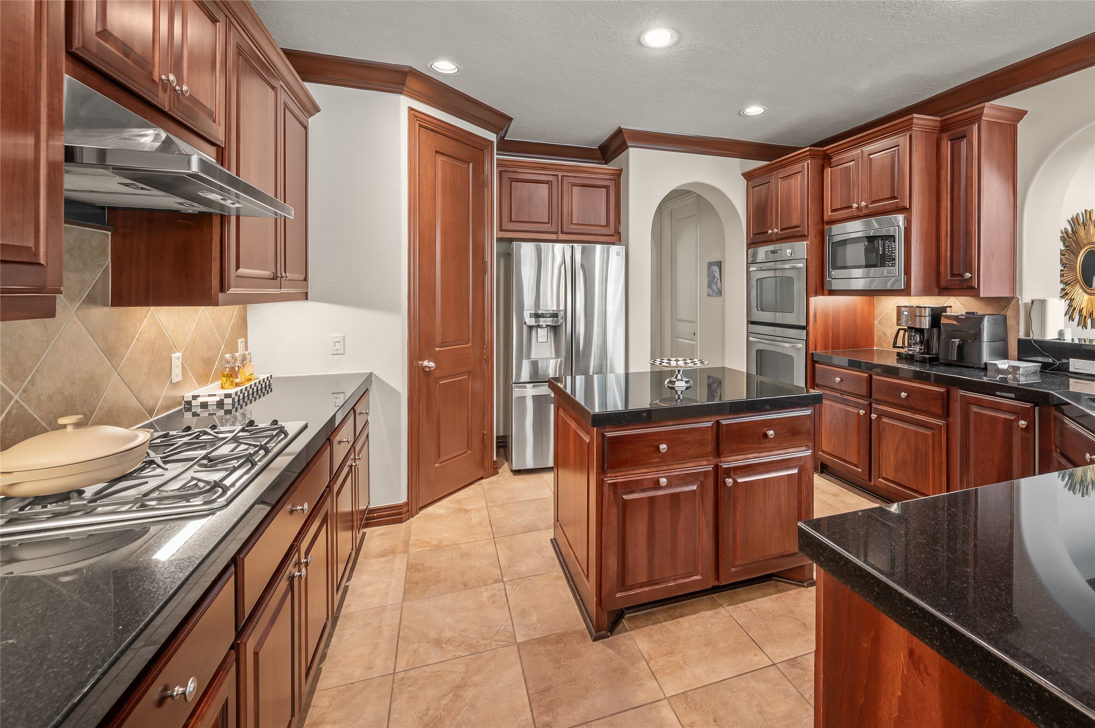 2127 Thicket Ridge Lane Houston, TX 77077 - Photo 15 of 48 The heart of the home is a masterpiece of design. This island-centric kitchen showcases a flawless fusion of bold granite, gleaming stainless steel, and heirloom-quality Benedettini cabinetry. Its open-concept flow makes it the perfect stage for high-end hosting, overlooking your private backyard paradise. There is also a double oven.