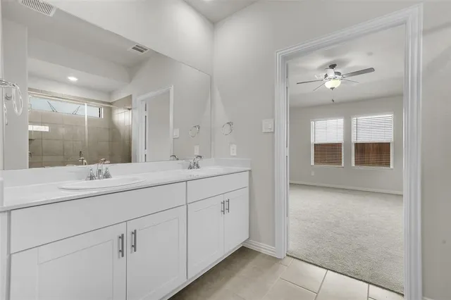 a bathroom with a double vanity sink and a mirror