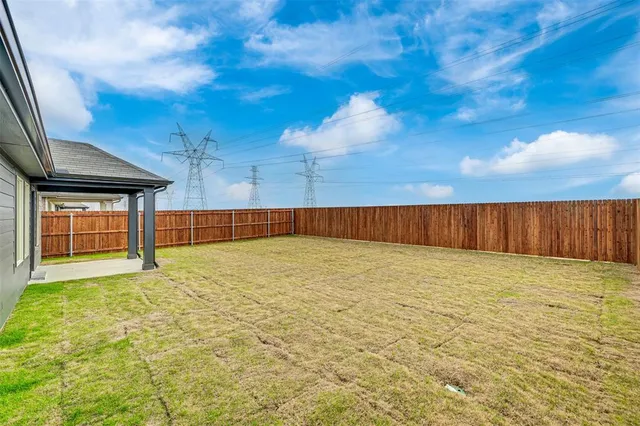 a view of an empty room with wooden floor and fan