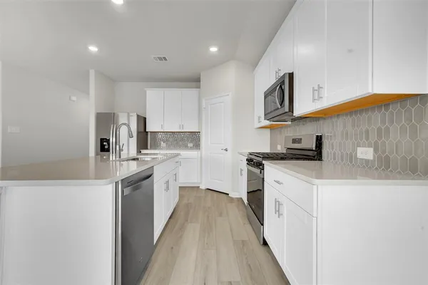 a kitchen with stainless steel appliances granite countertop a sink and a stove
