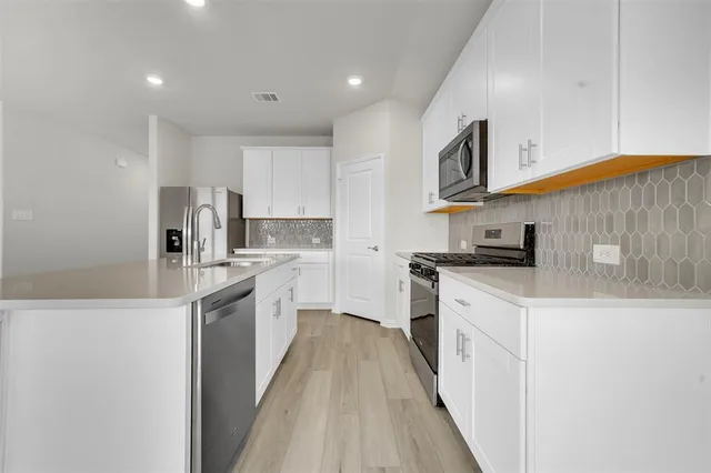 a kitchen with stainless steel appliances granite countertop a sink and a stove