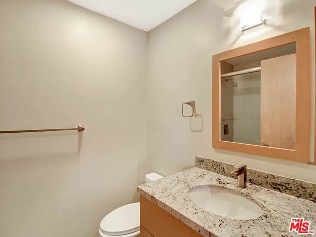 a bathroom with a granite countertop sink toilet and shower