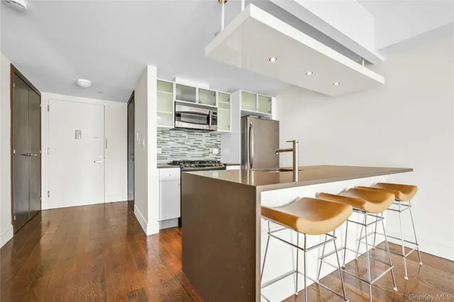 a kitchen with stainless steel appliances a refrigerator and wooden floor