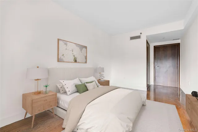 a bedroom with a bed and a painting on the wall