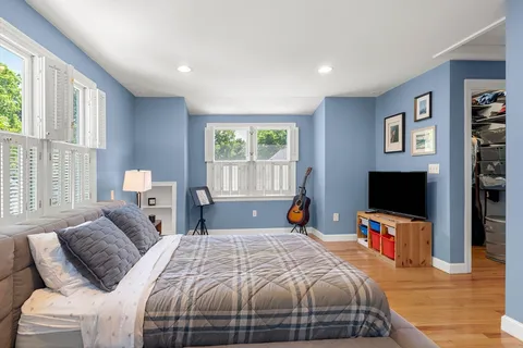 a bedroom with a bed and wooden floor