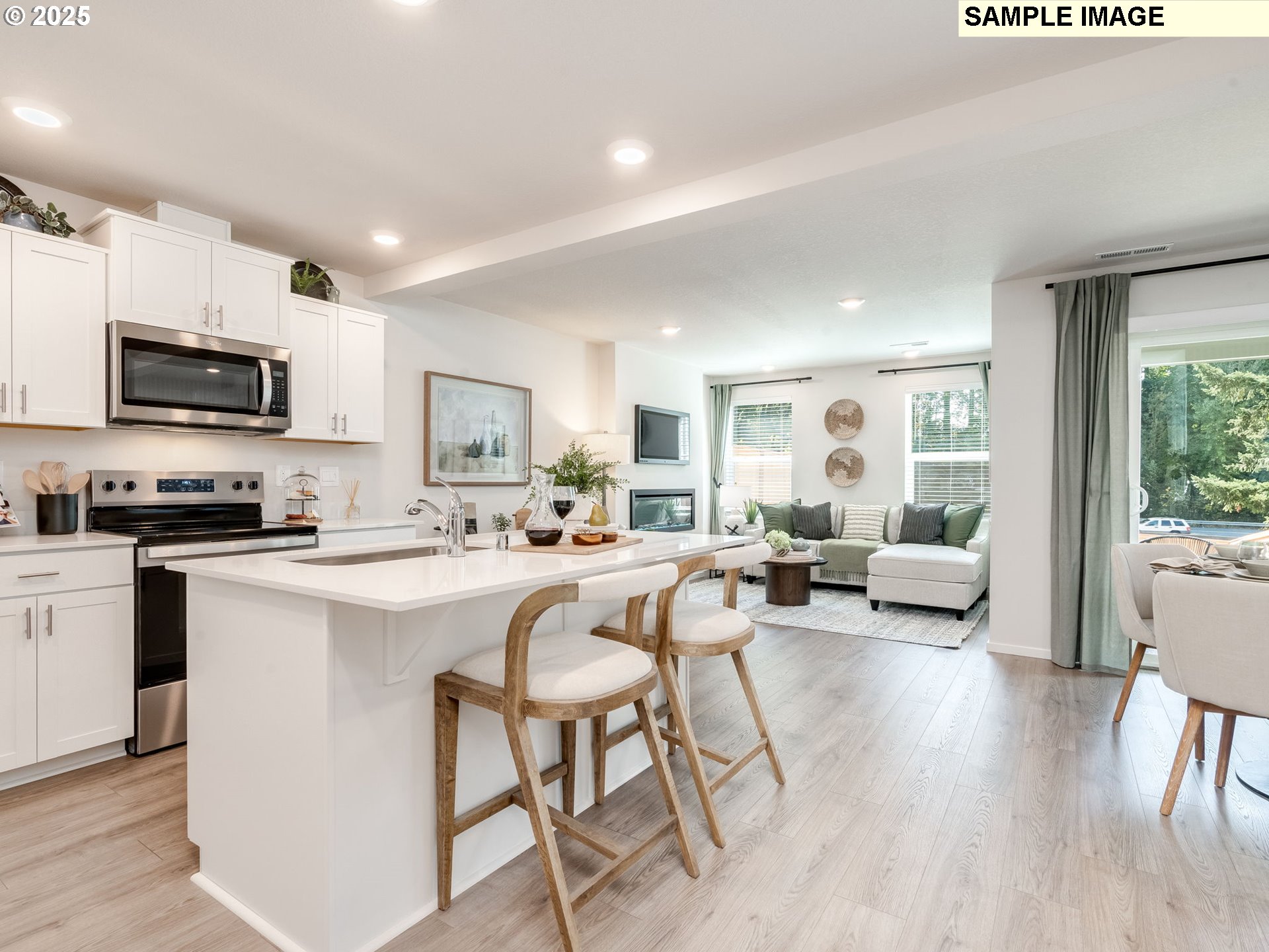 11116 Southeast Maxon Road Vancouver, WA 98664 - Photo 4 of 30 a living room with stainless steel appliances a kitchen island furniture a flat screen tv a rug and a window
