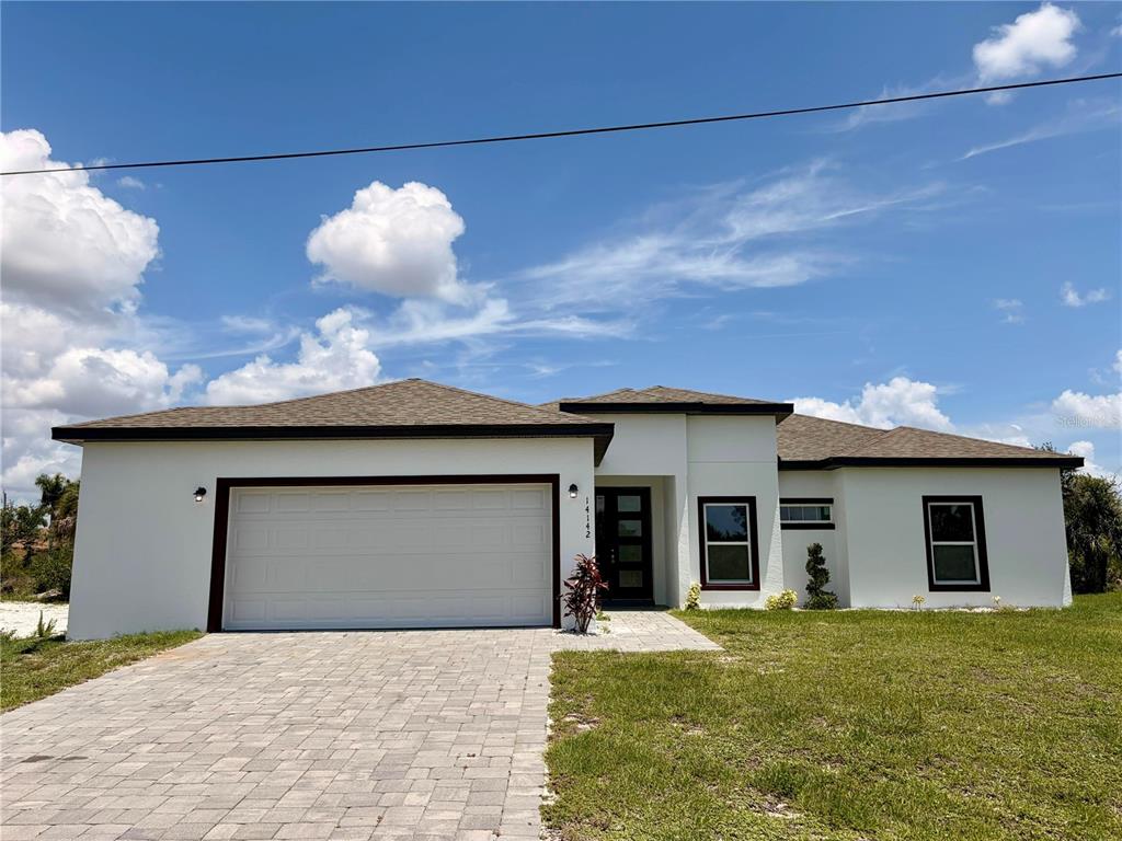 14142 Appleton Boulevard Port Charlotte, FL 33981 - Photo 1 of 26 a front view of a house with a yard and garage