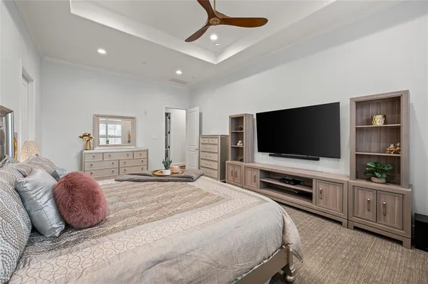 a spacious bedroom with a bed a couch and a large window