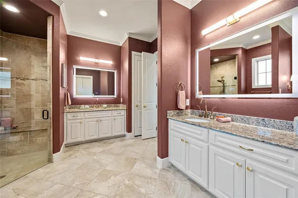 a spacious bathroom with a granite countertop sink a mirror and a bathtub