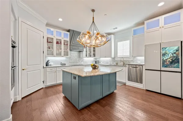 a view of a dining room with furniture a kitchen and chandelier