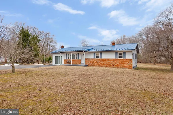 a front view of house with yard and trees in the background